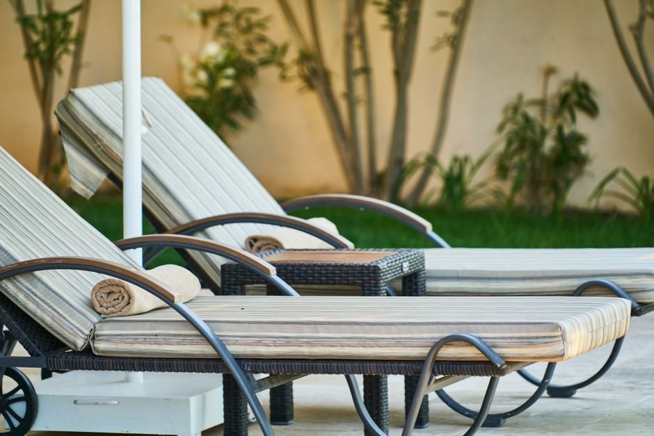 Outdoor patio furniture set with cushioned loungers on a backyard patio