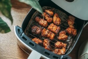 Crispy chicken cooking inside a modern air fryer basket