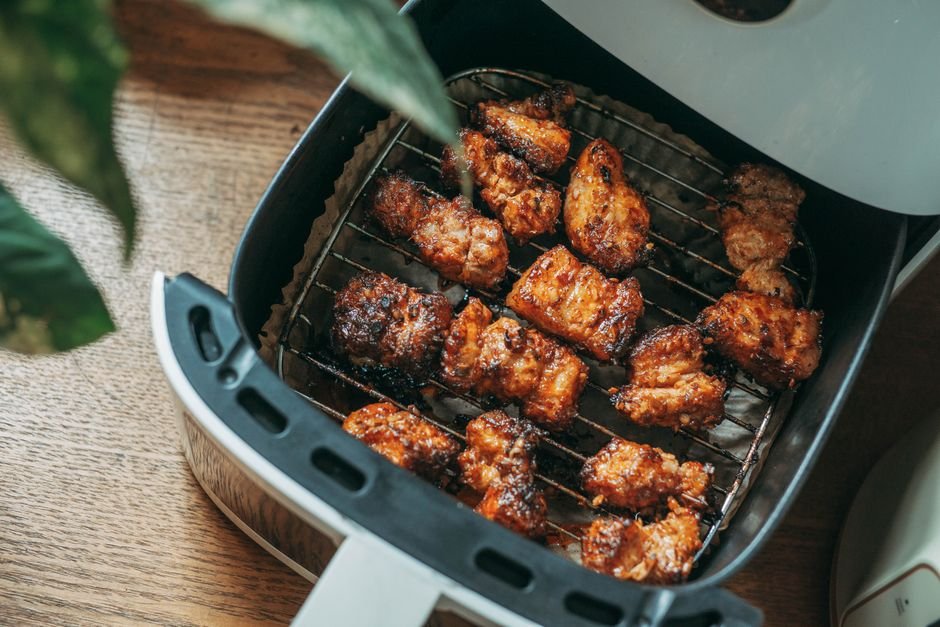 Crispy chicken cooking inside a modern air fryer basket