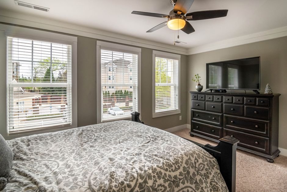 Bedroom with a low-profile ceiling fan and light over the bed