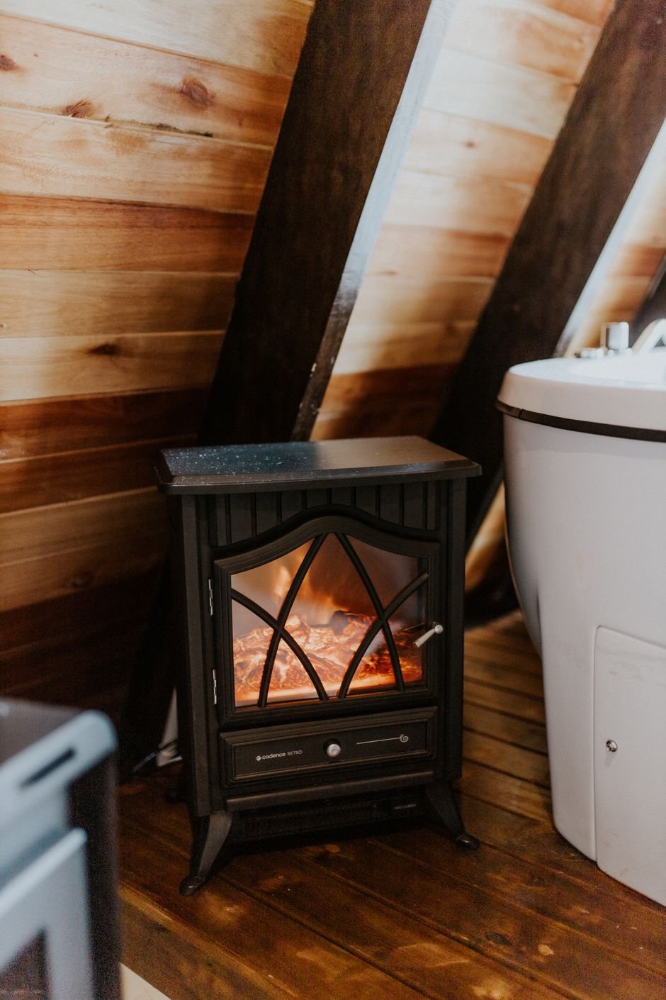 Electric stove-style space heater with a glowing flame effect in a cabin