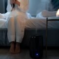 Modern humidifier releasing cool mist in a cozy bedroom for comfortable air