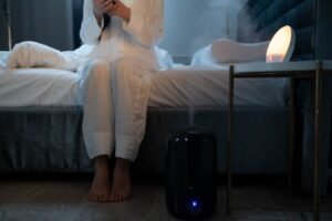 Modern humidifier releasing cool mist in a cozy bedroom for comfortable air