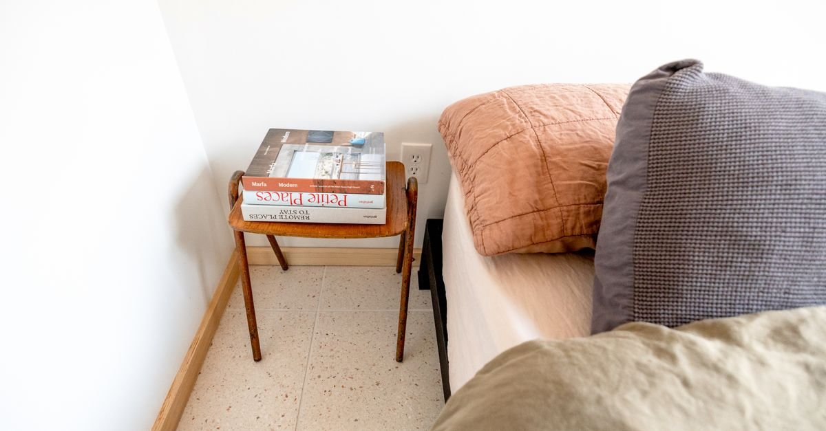 A slim bedside table in a small bedroom