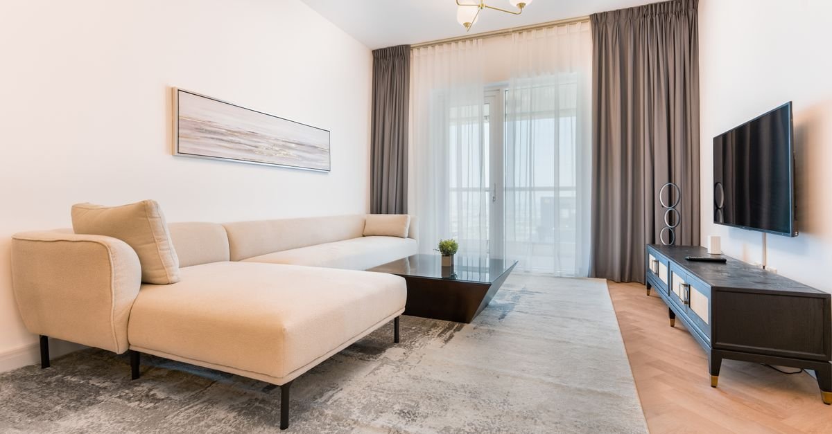 Neutral living room with rug anchoring the seating area