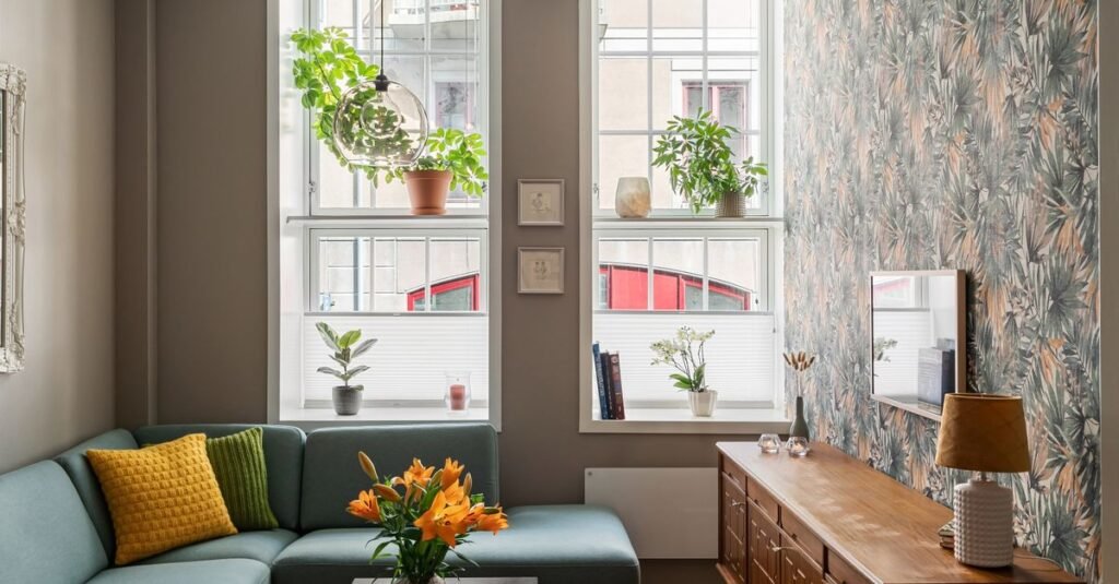 A small cozy living room with a large window and plants A small cozy living room with a large window and plants
