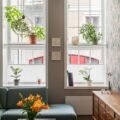A small cozy living room with a large window and plants