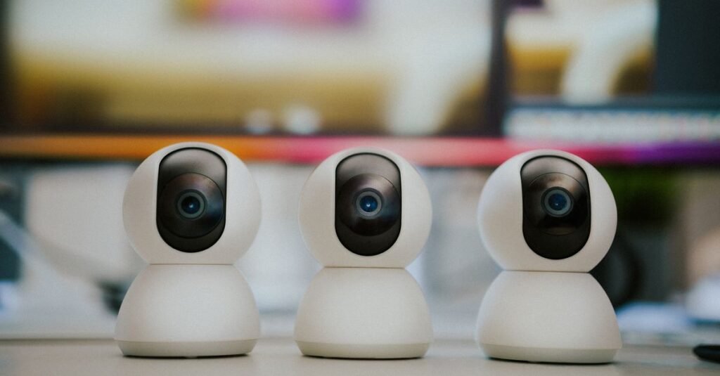 Three white pan-tilt camera units in a row