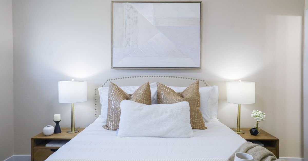 A symmetrically styled bed with matching nightstands and lamps