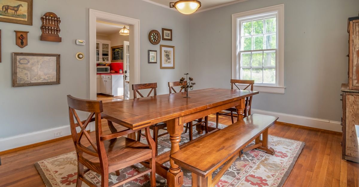 Dining table and chairs sitting fully on an area rug