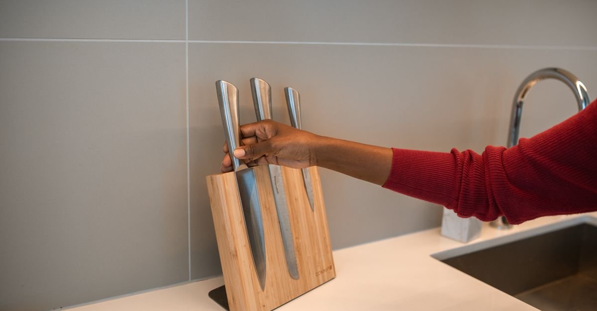 Placing kitchen knives into a wooden block
