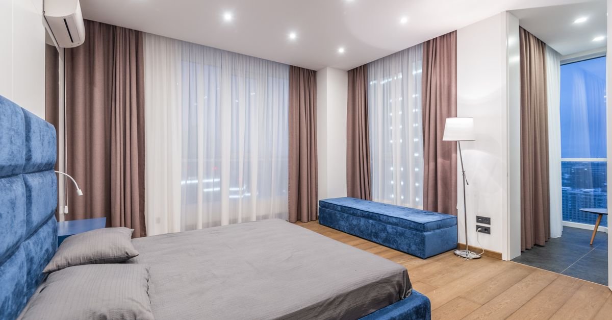 Bedroom with full-height curtains at the window