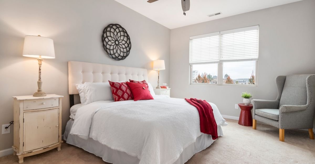 A ceiling fan with a light in a bedroom
