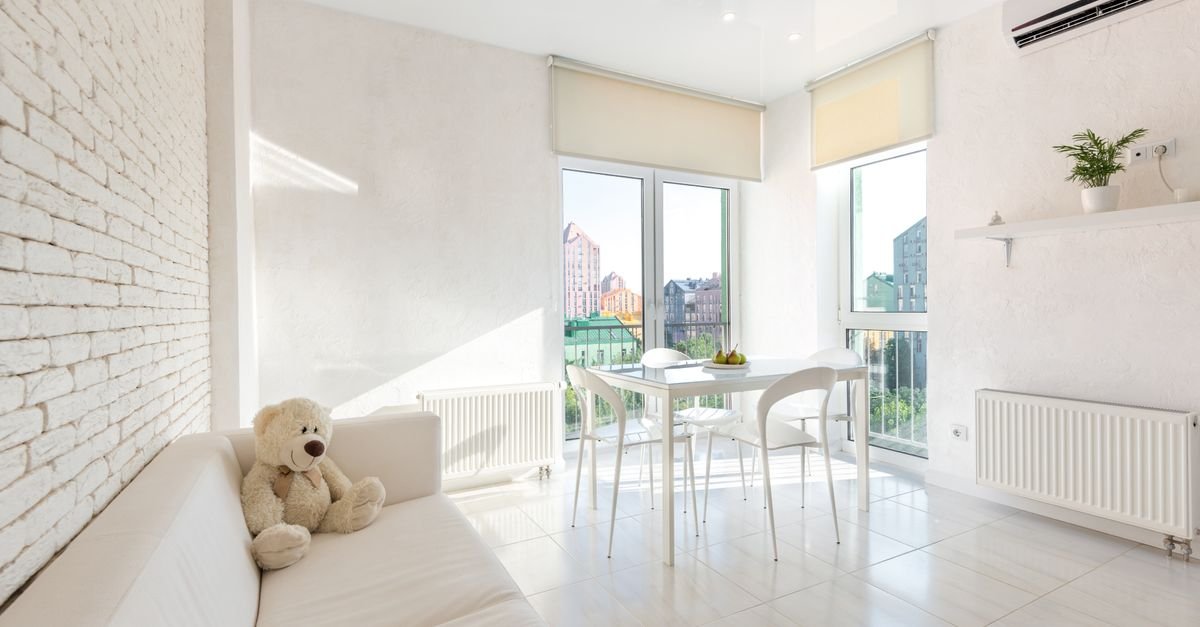 A room set up for a portable air conditioner near a window