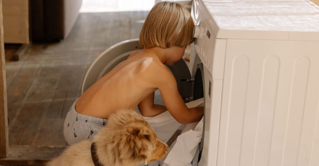 Child and dog watching the washing machine