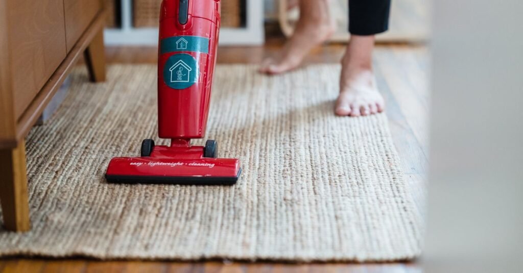 Stick vacuum gliding over a woven rug