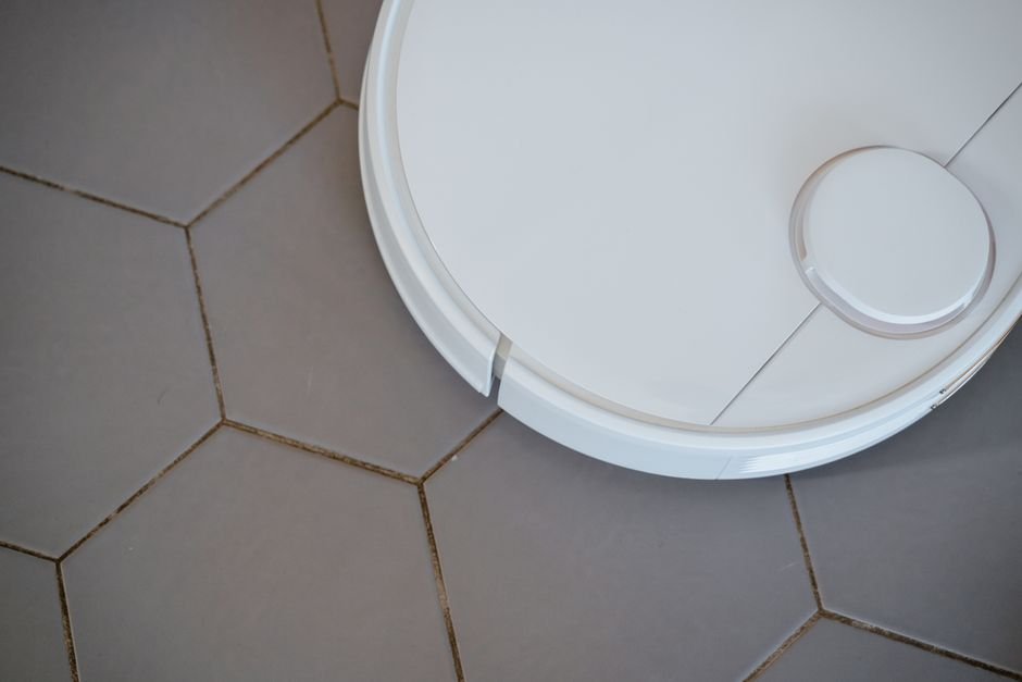 Robot mop autonomously cleaning a hard floor in a modern smart home