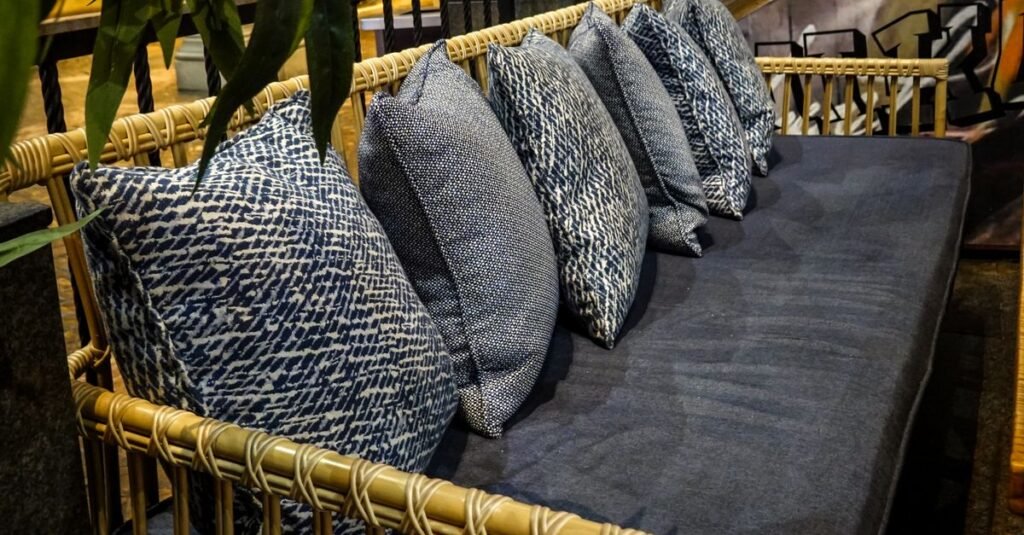 Dark rattan sofa stacked with cushions