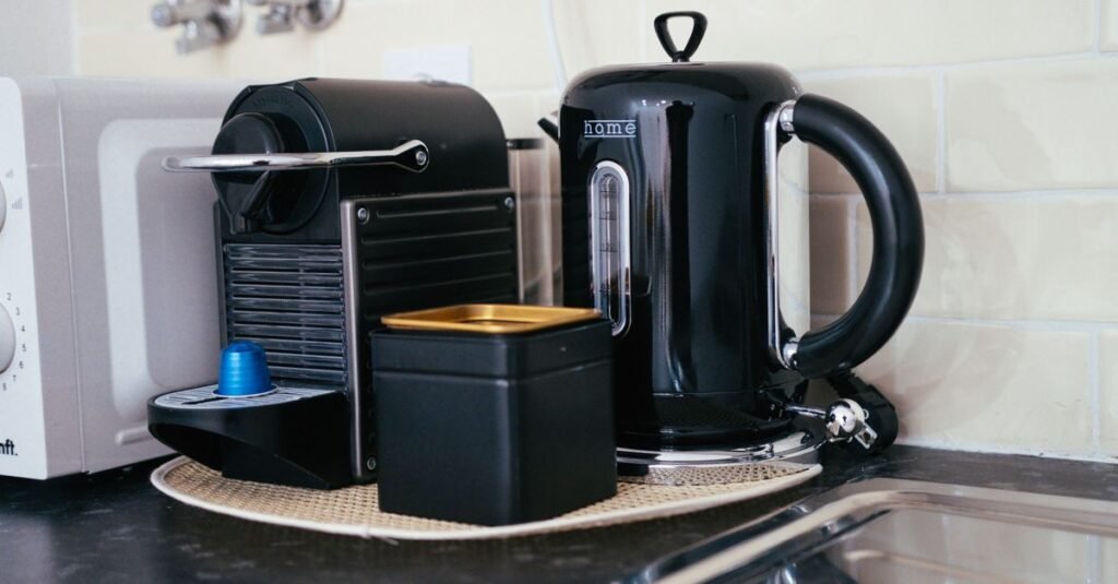 Pod machine and kettle in a dark kitchen corner
