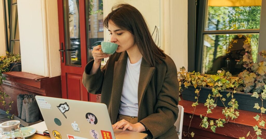 Woman with coffee working at a window terrace