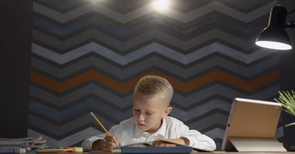 Boy focused at a desk with warm lighting