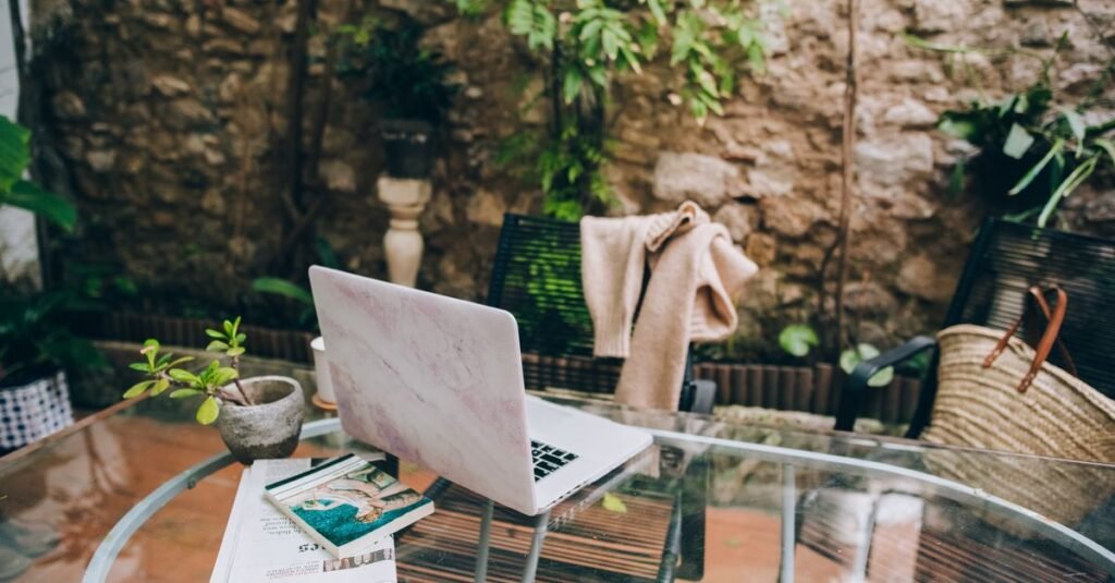 Laptop on a glass table in a walled garden
