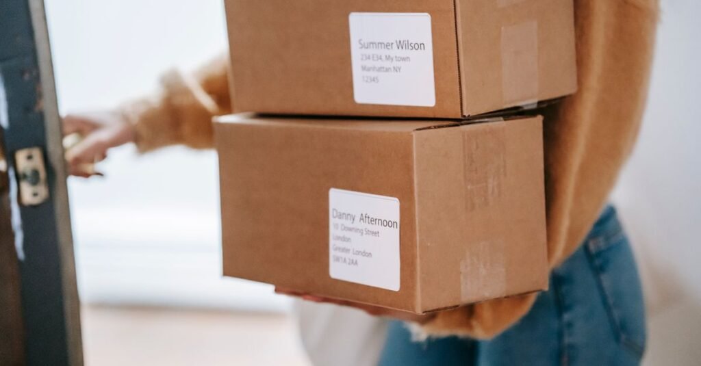 Person carrying stacked delivery boxes