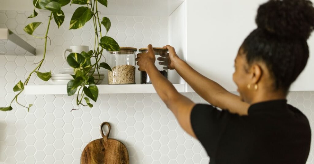 Woman reaching into an organized kitchen shelf
