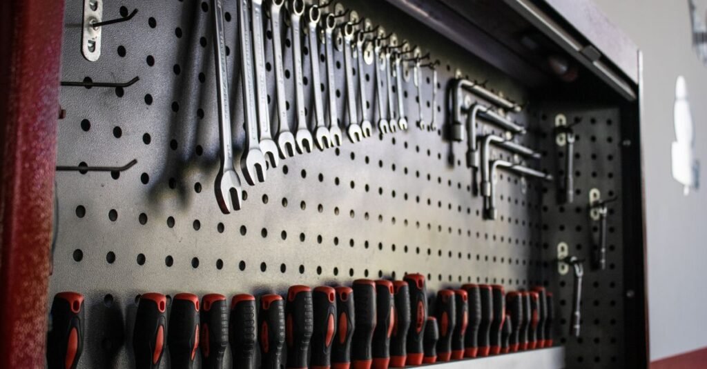 Wrenches and tools organized on a black pegboard wall