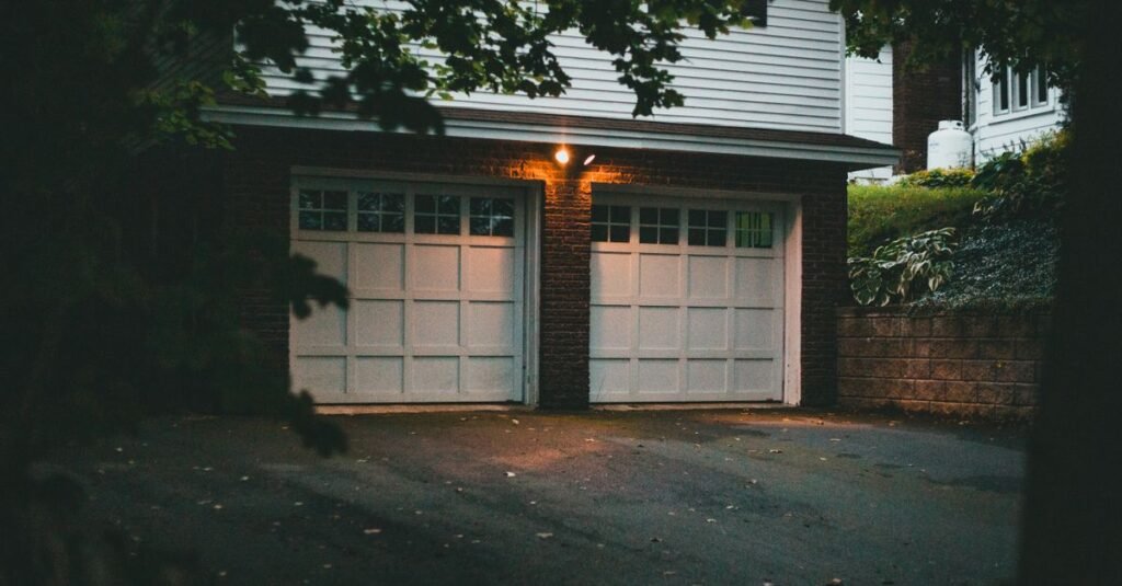 Garage doors lit by an overhead fixture at night