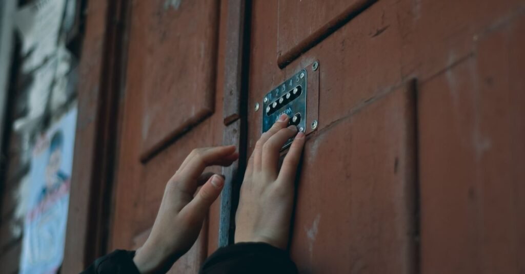 Hands entering a code on a door keypad
