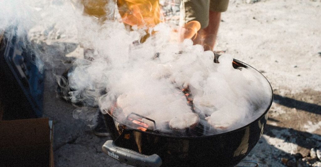Smoke rising from a charcoal kettle grill